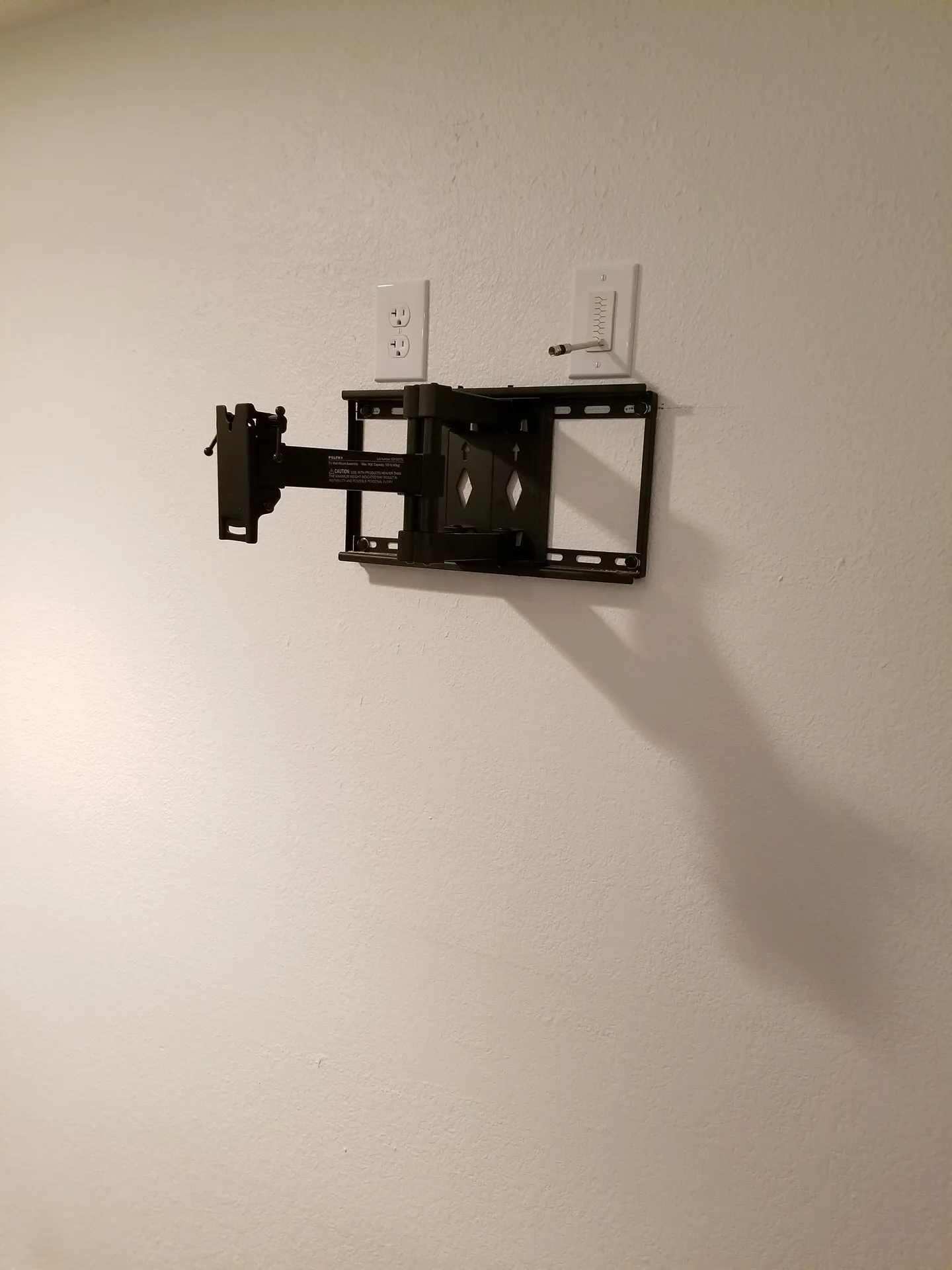 Un supporto per la TV è appeso a una parete bianca.