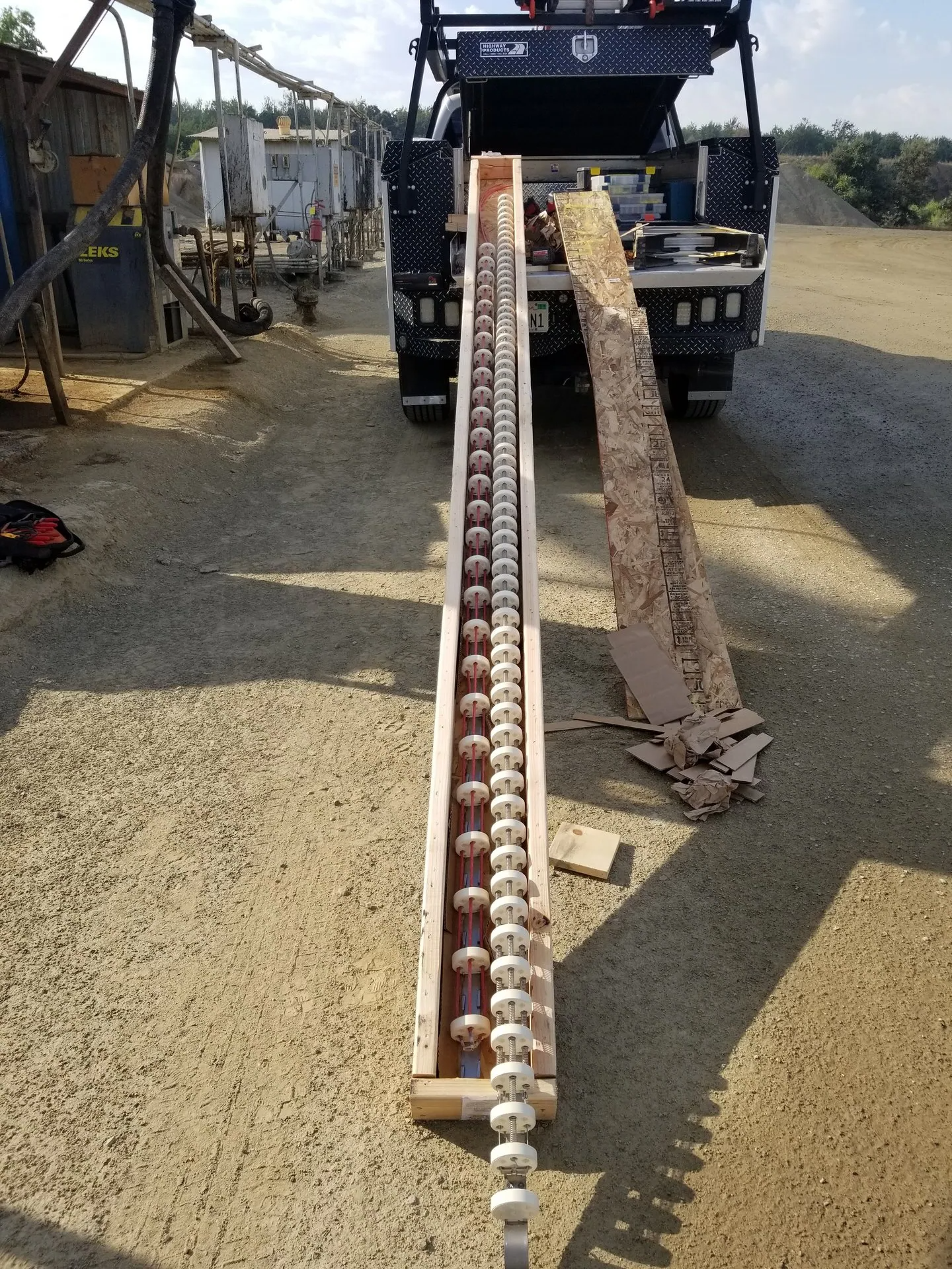 A large piece of wood is sitting on the ground next to a truck.
