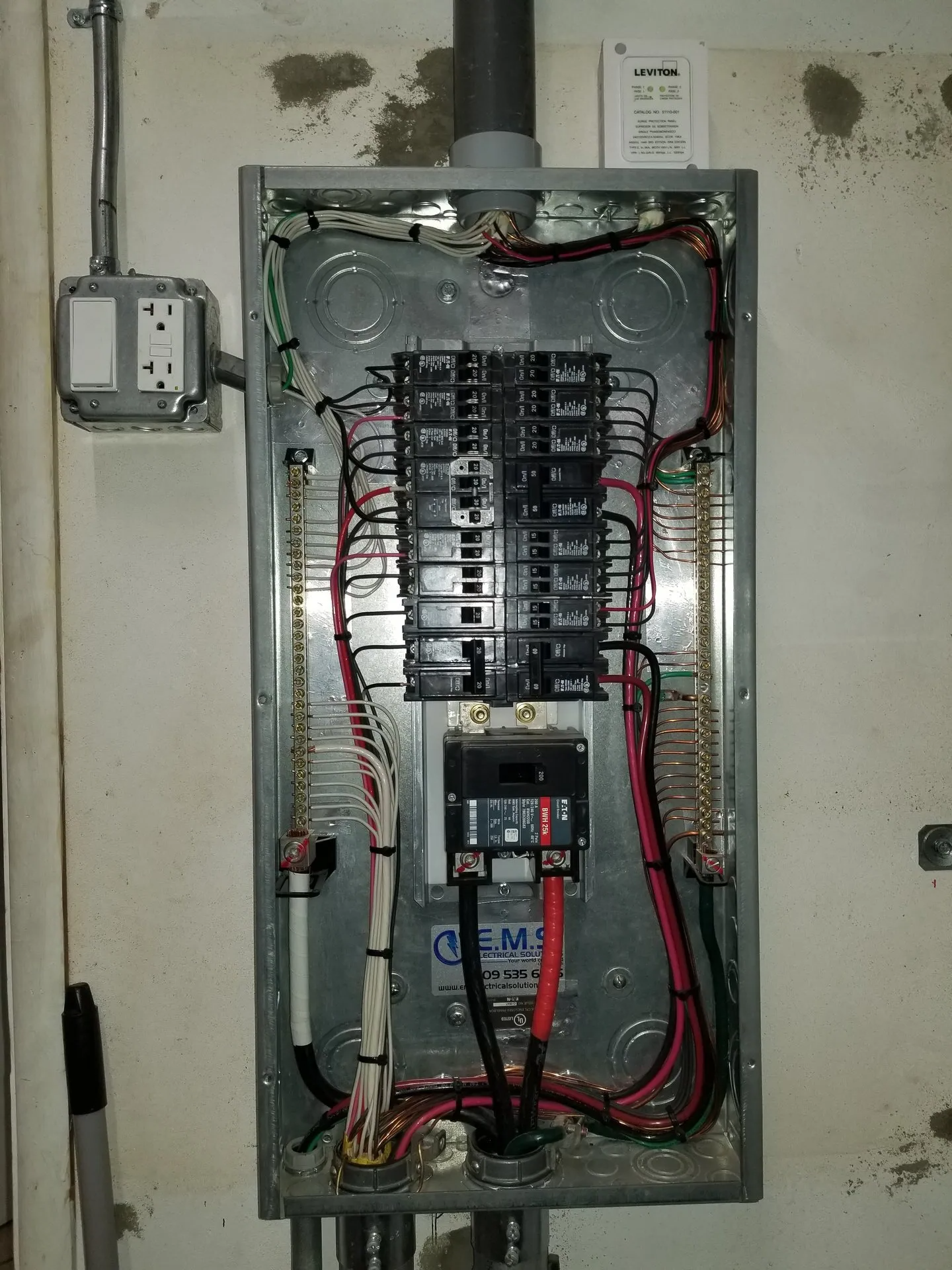 A electrical panel with a lot of wires coming out of it.