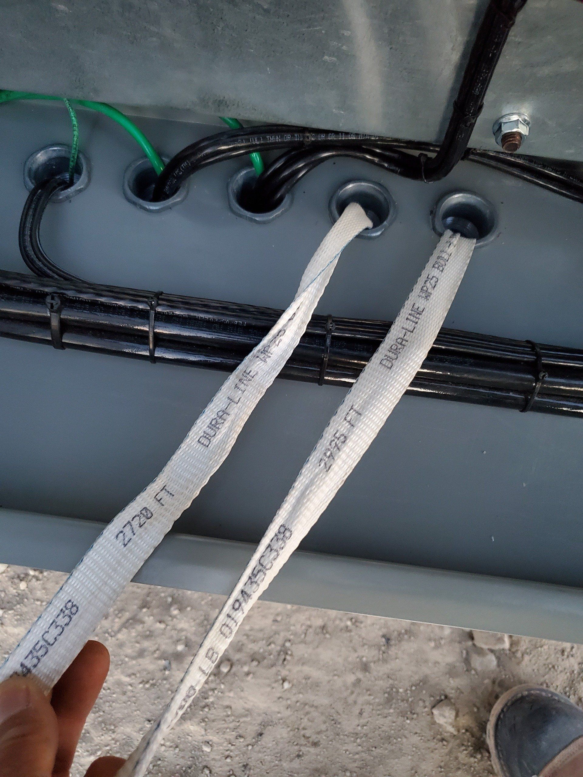 A person is holding two electrical wires in their hand