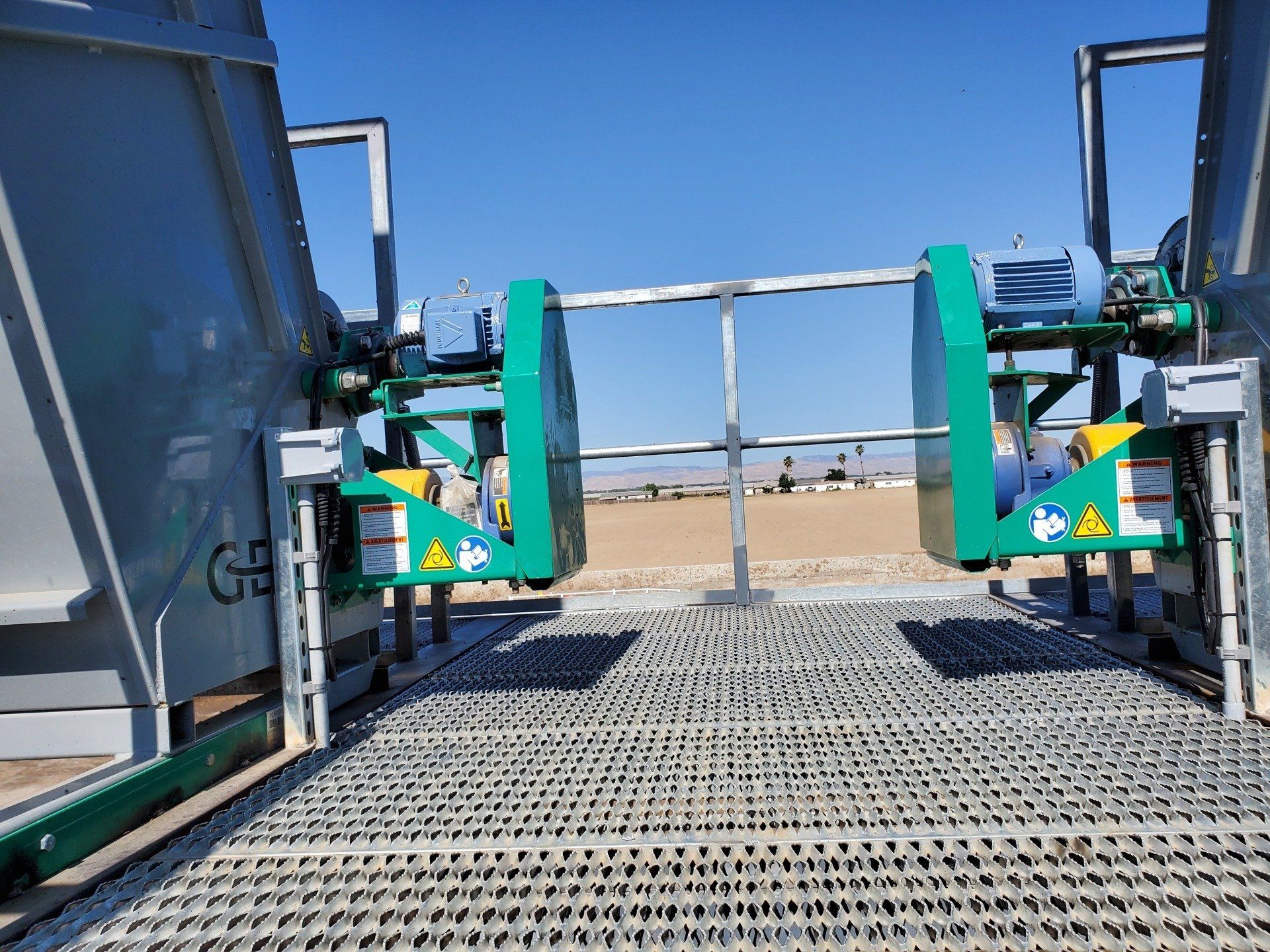 A green machine is sitting on top of a metal platform.