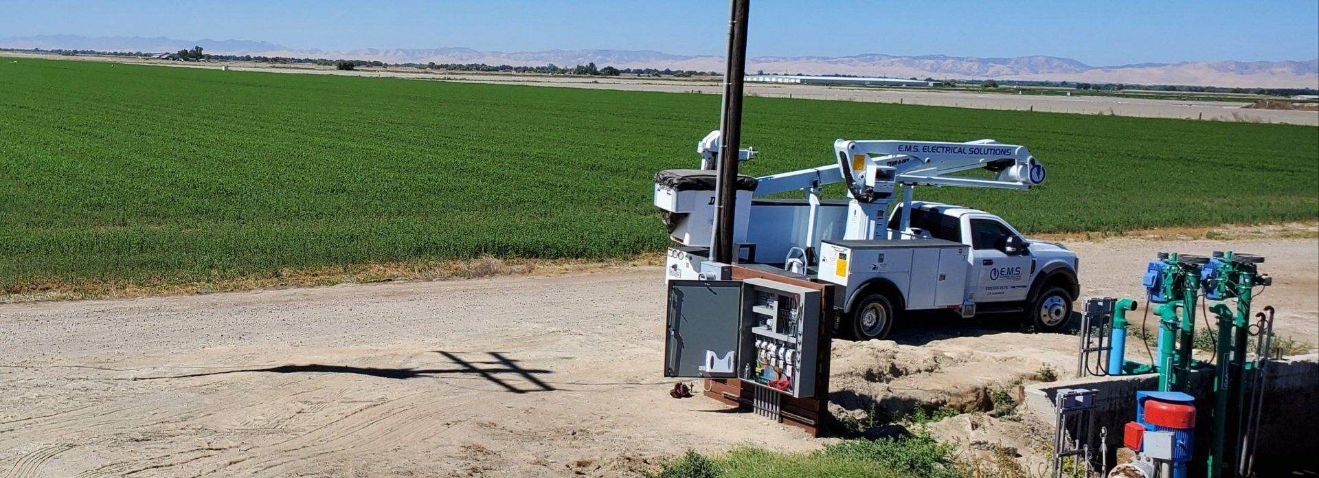 A white truck is parked in the middle of a field.