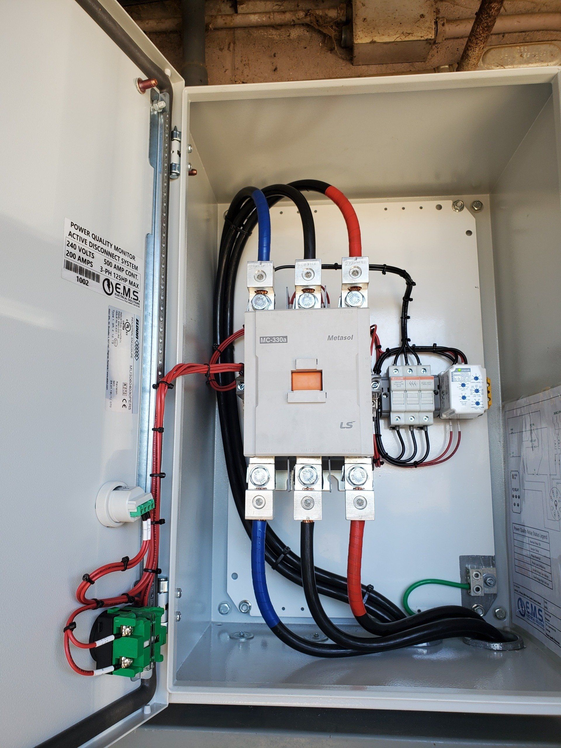 Una scatola bianca da cui escono un sacco di fili.