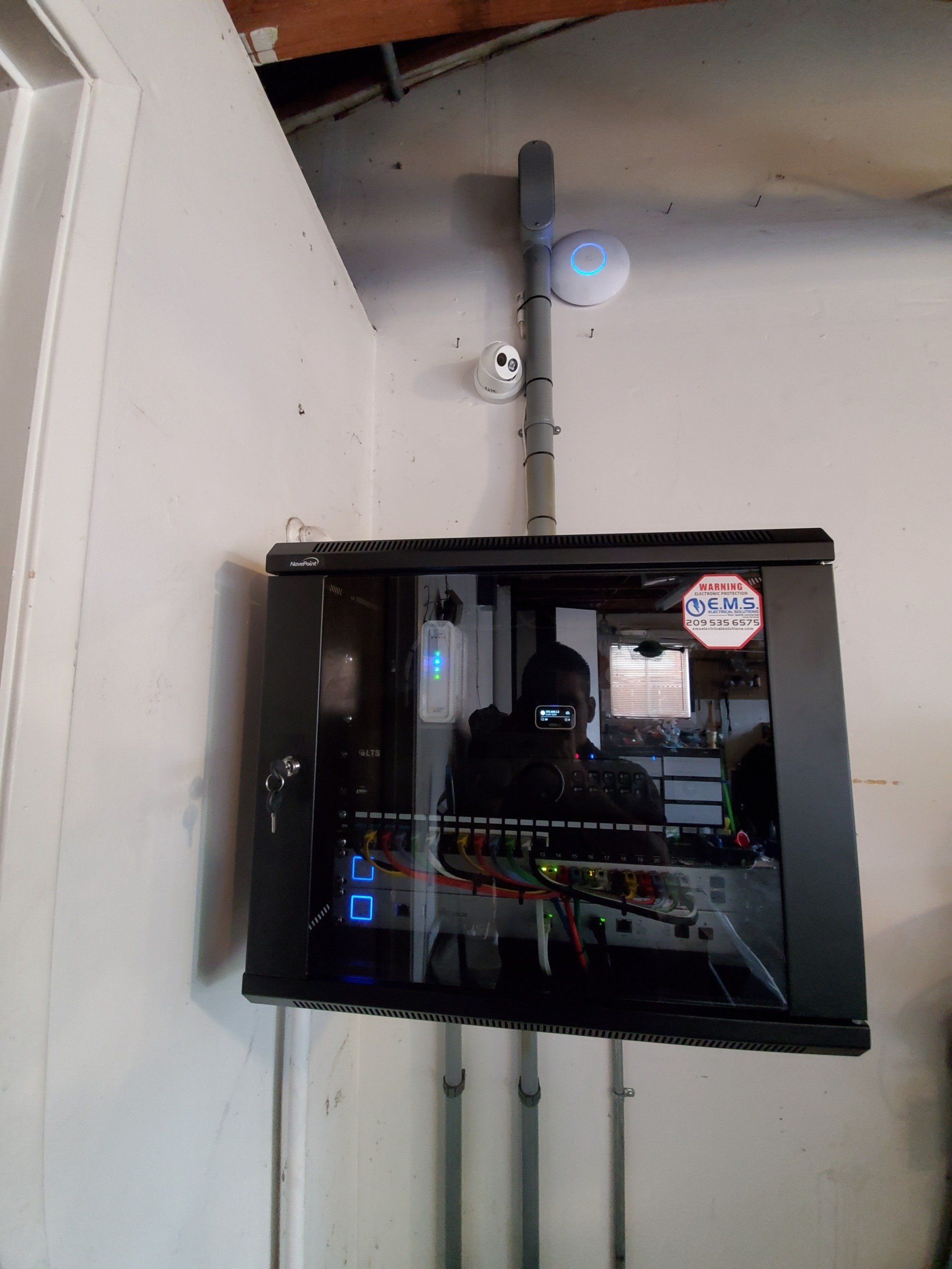 A tv mounted on a wall with a sticker that says E.M.S. Electrical Solutions