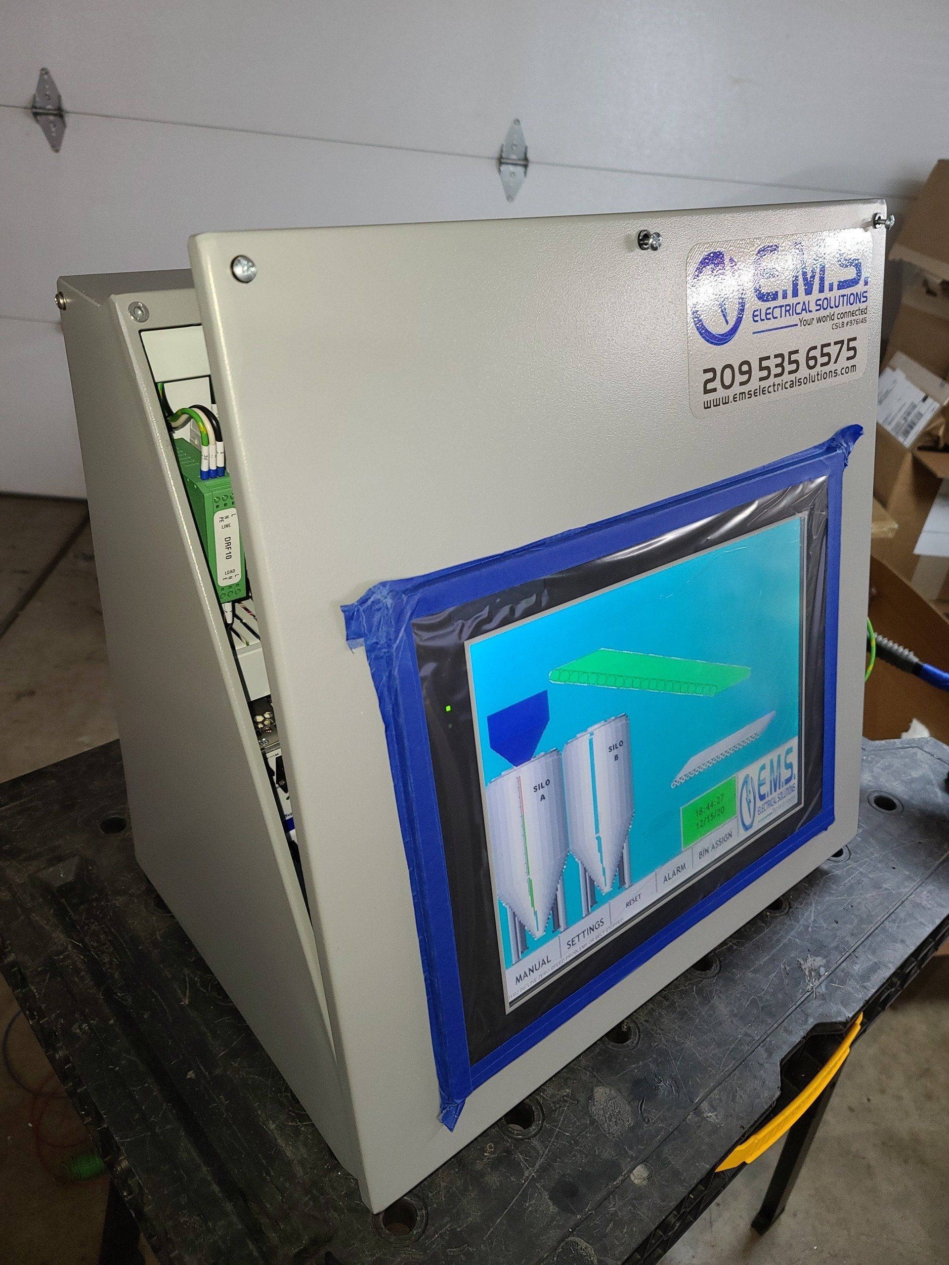 Una scatola bianca con un nastro blu che copre lo schermo è appoggiata su un tavolo.