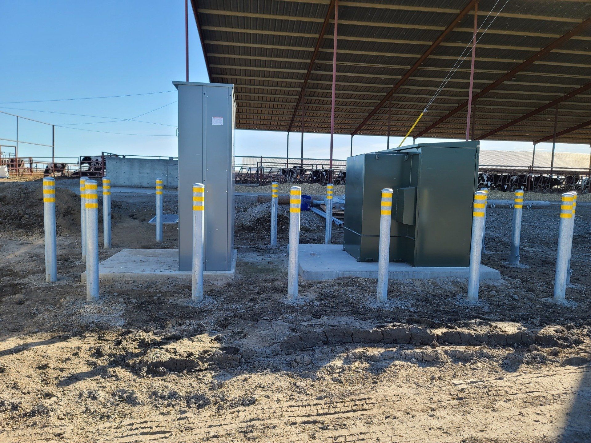 Vor einem Gebäude stehen viele Pfosten im Dreck.