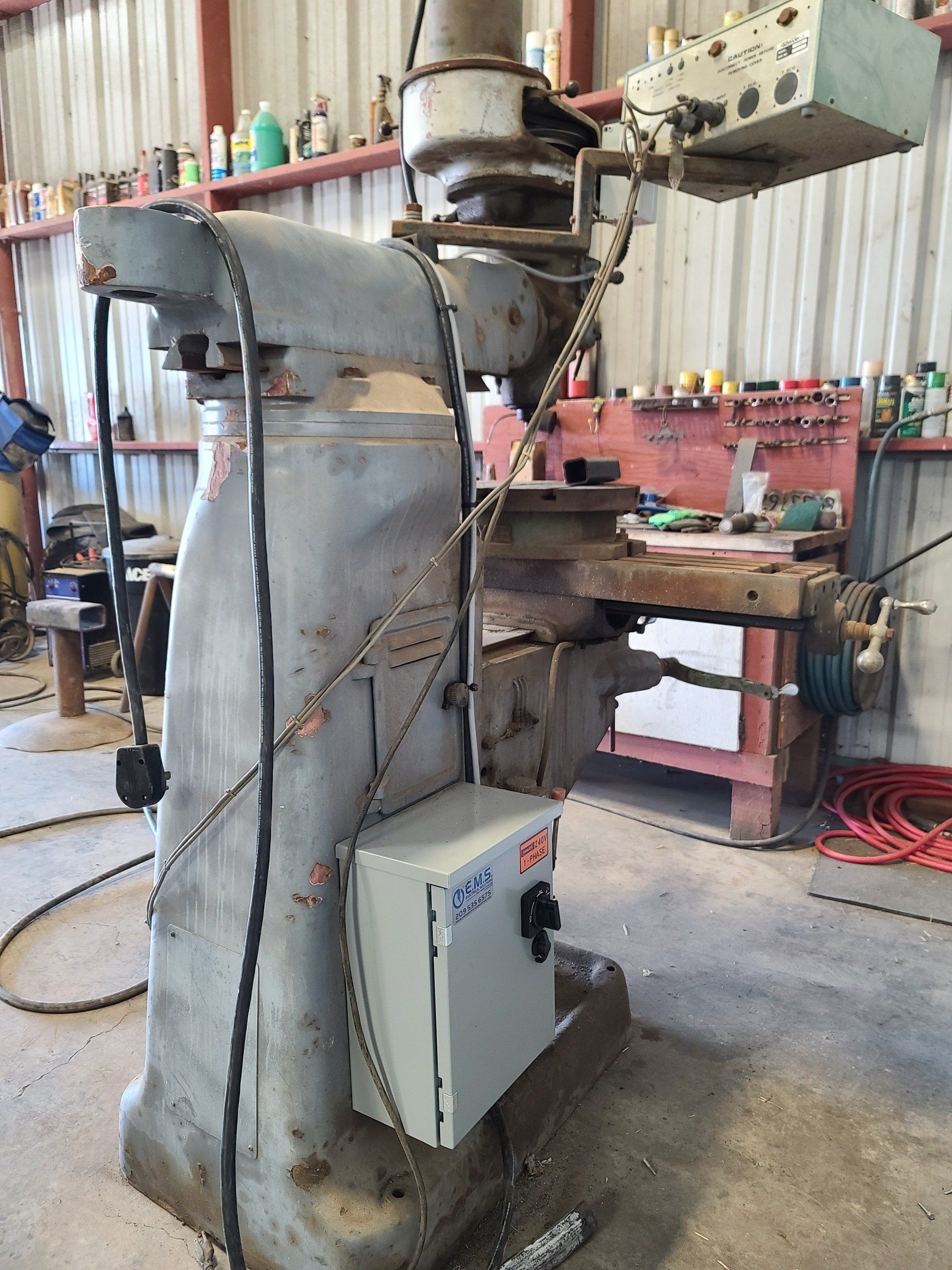 Una macchina è parcheggiata in un garage accanto a un banco da lavoro.