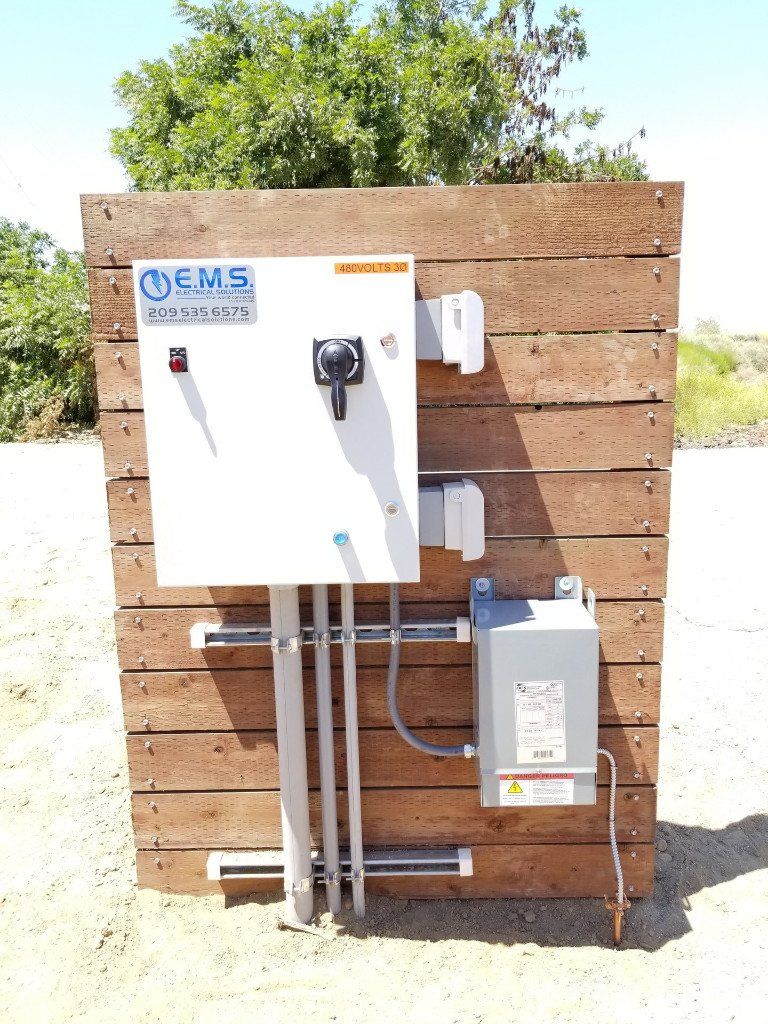 An EMS electrical box is mounted on a wooden wall