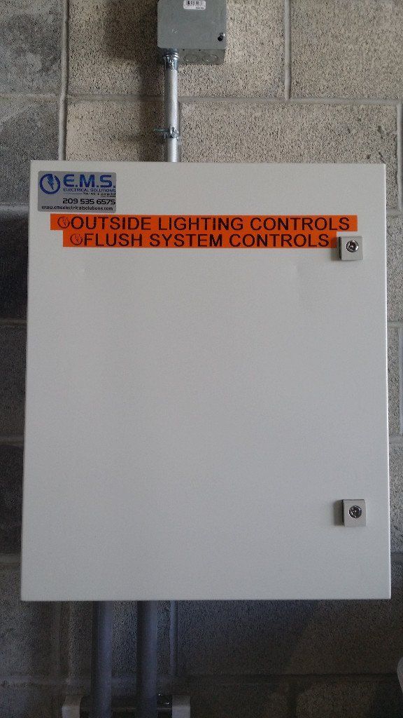A white box with a sticker on it that says outside lighting controls and flush system controls.