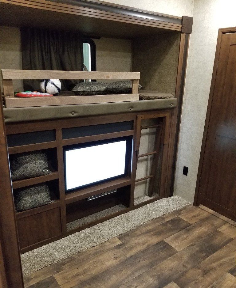 A bedroom with bunk beds and a flat screen tv