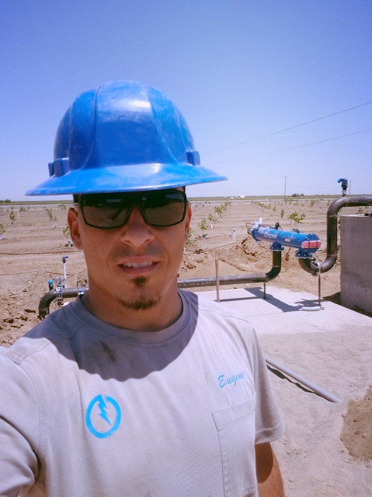 Eugene Silva wearing a blue hard hat and sunglasses at jobsite