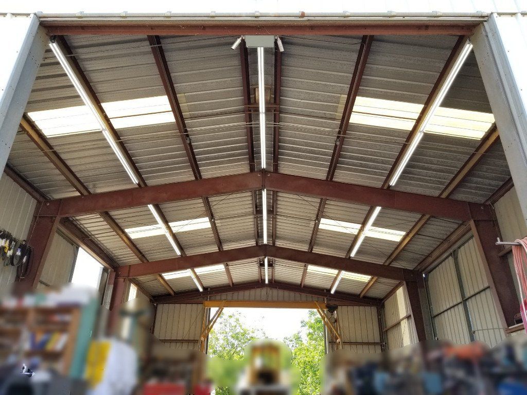 The inside of a large metal building with a roof that is open.