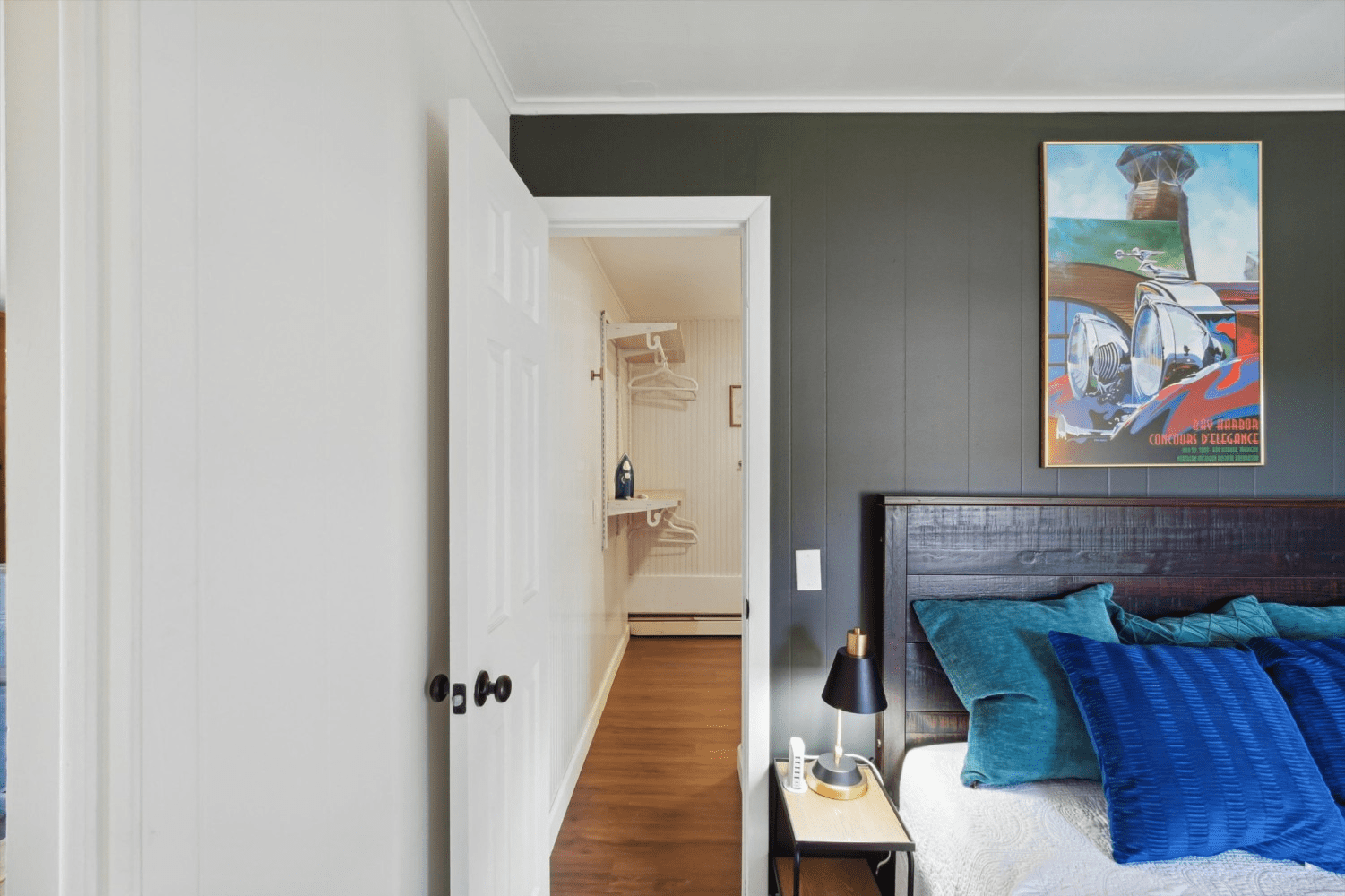 A bedroom with a bed and a painting on the wall.