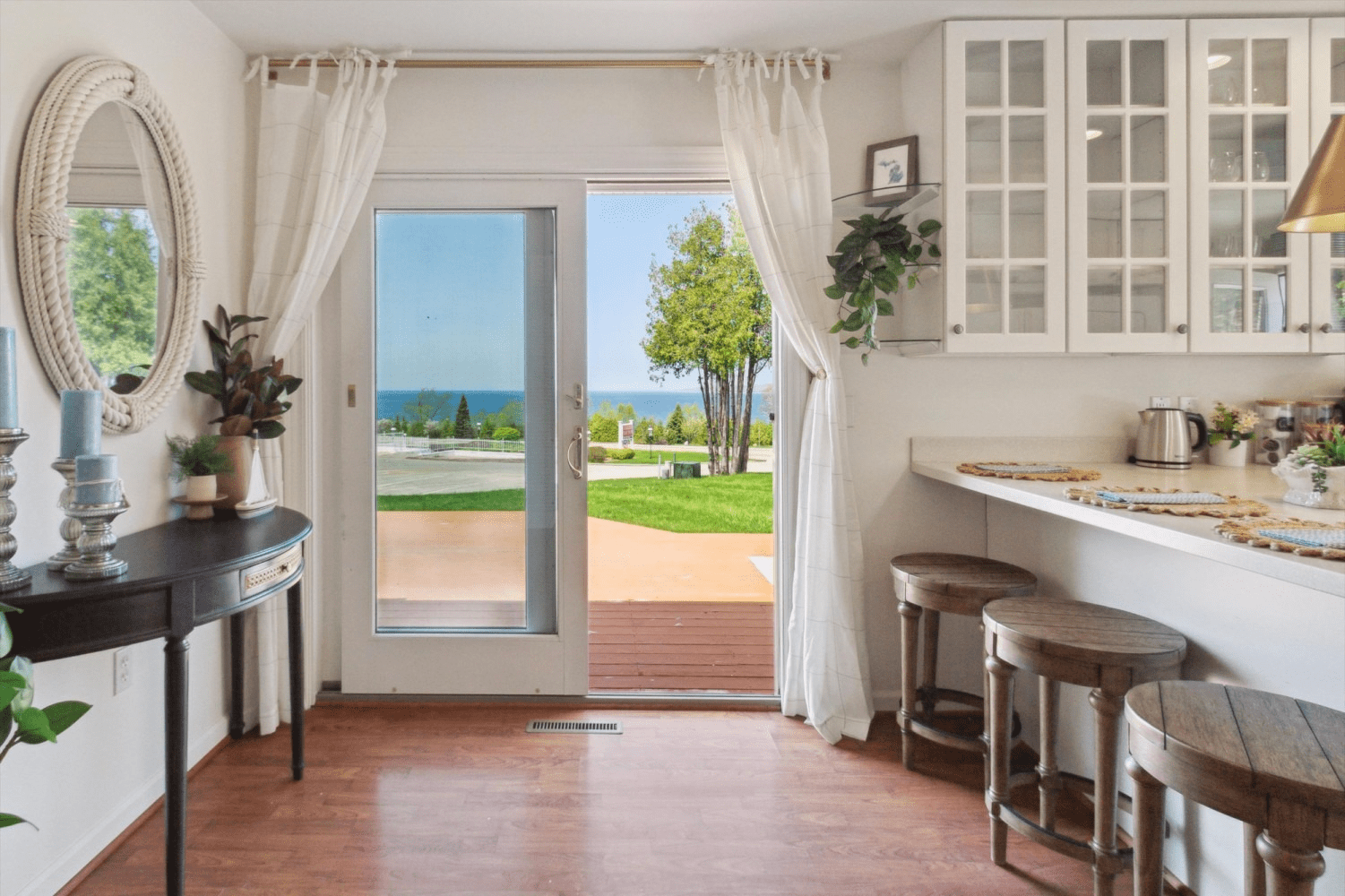 A kitchen with a sliding glass door and a view of the ocean.