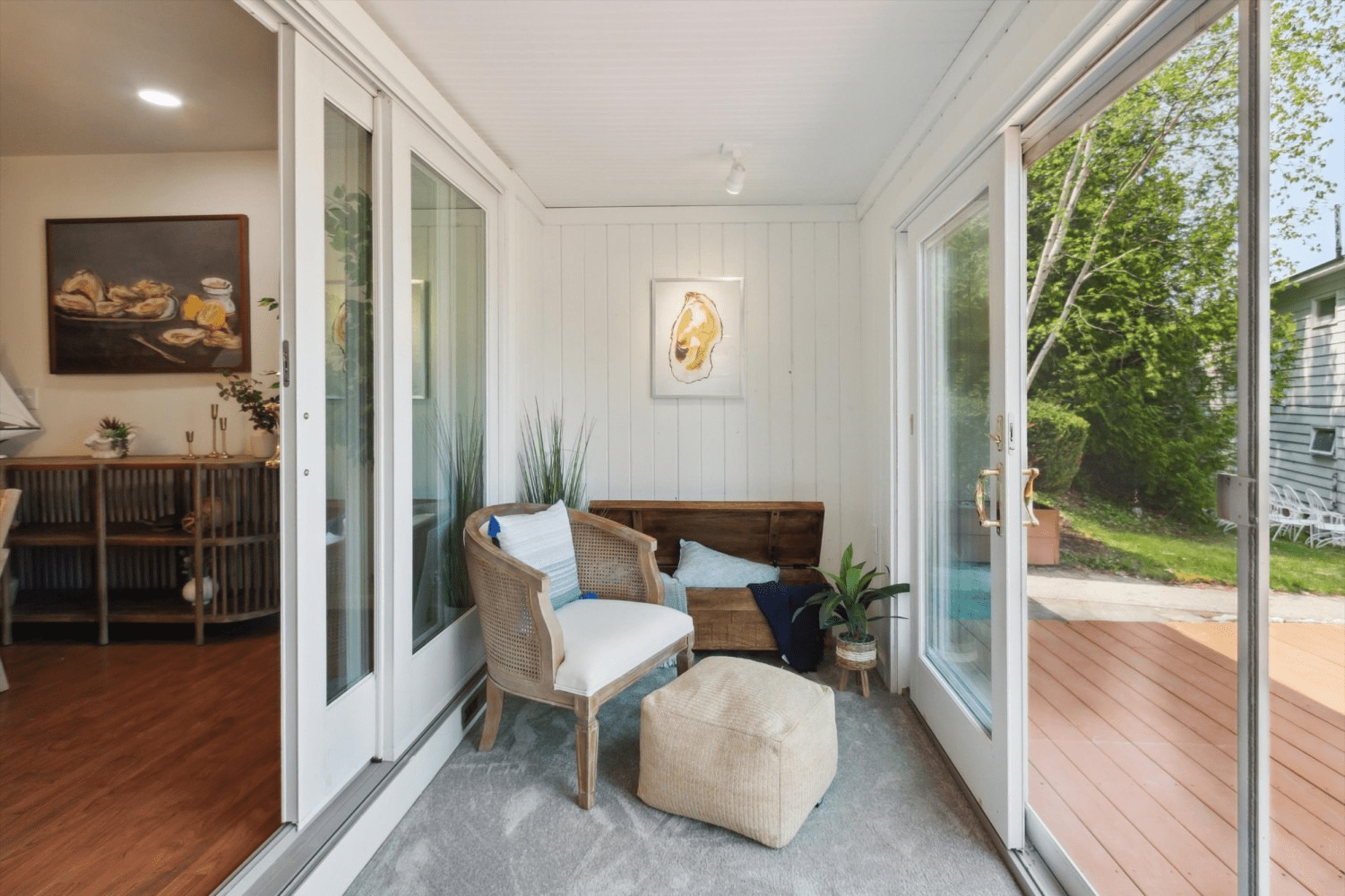 A living room with a couch , chair , ottoman and sliding glass doors.