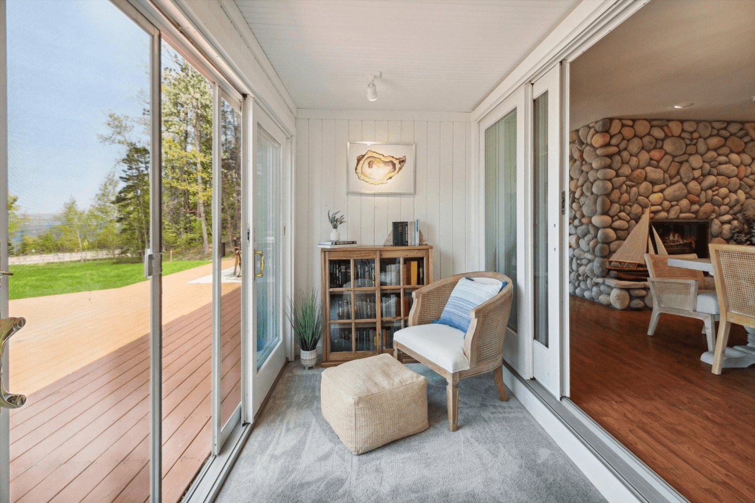 A living room with sliding glass doors leading to a deck and a fireplace.