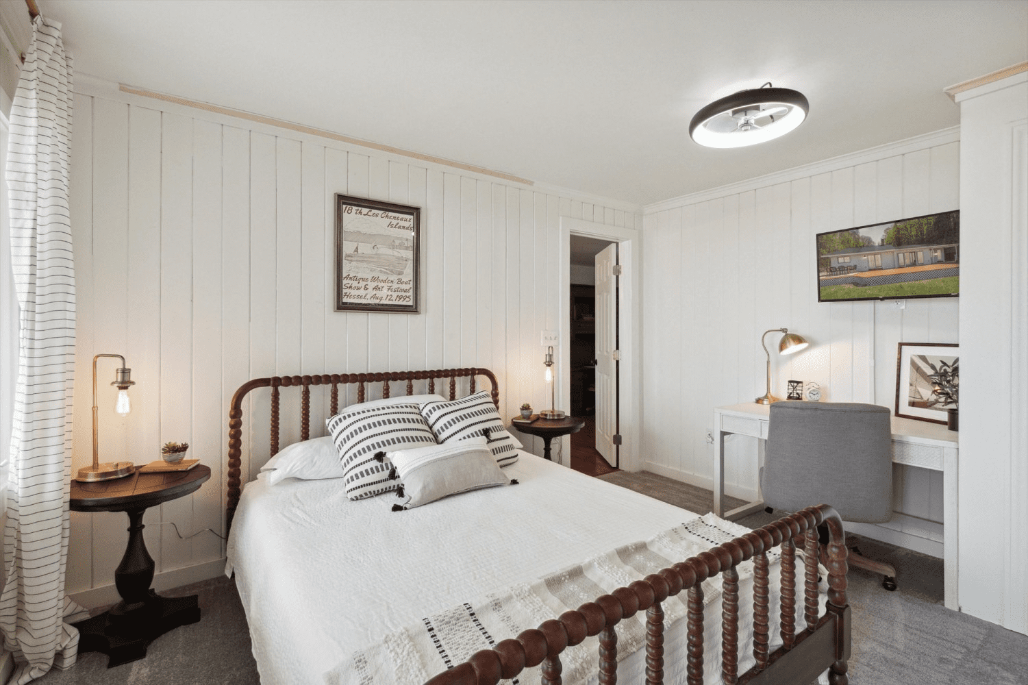 A bedroom with a bed , desk and nightstand.