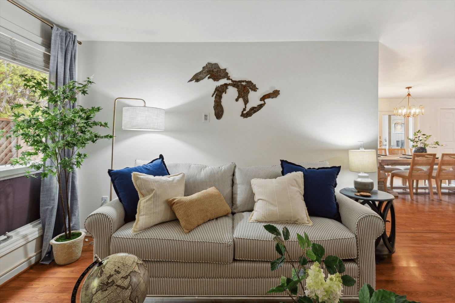 A living room with a striped couch and blue and white pillows.