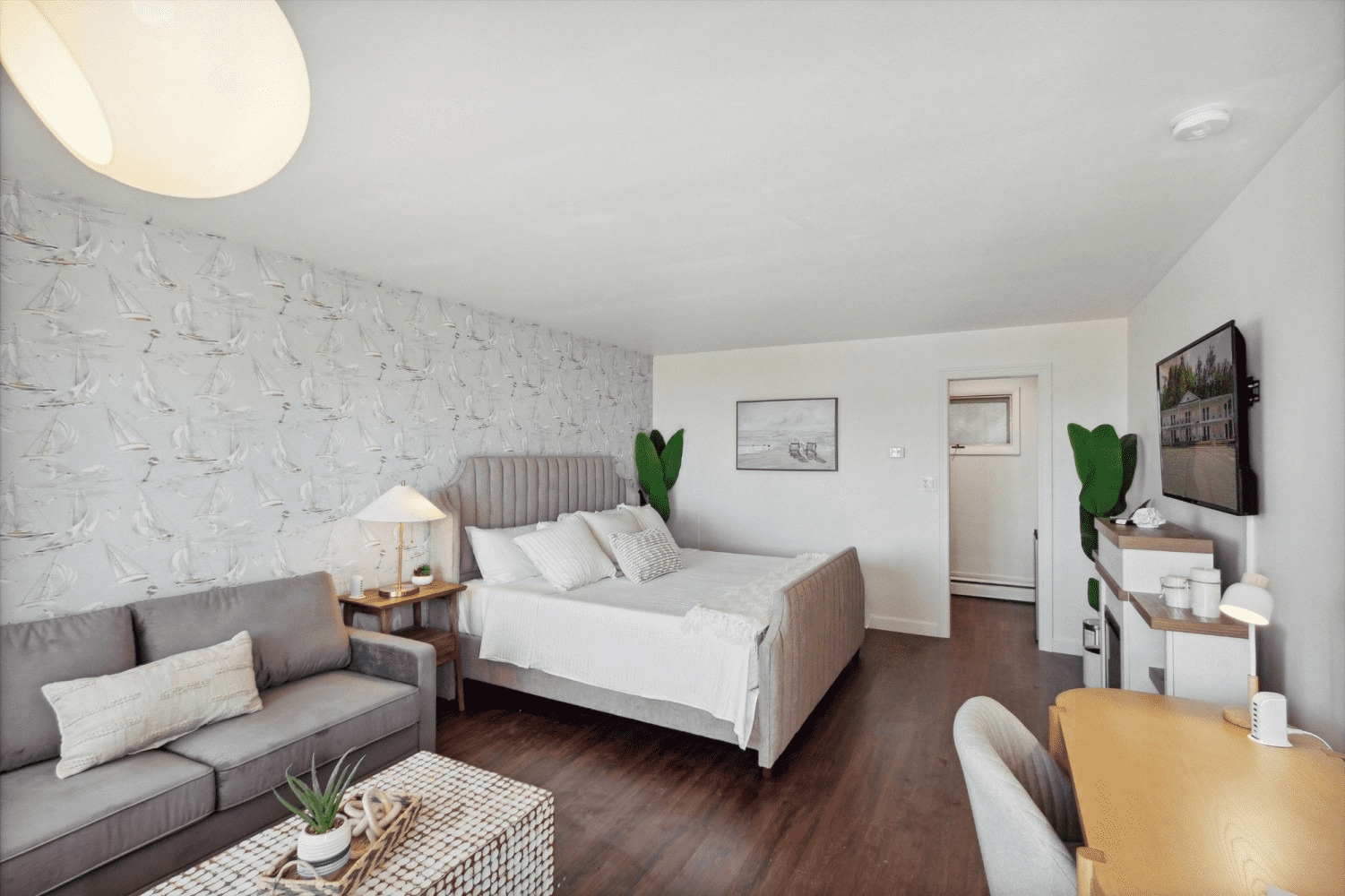 A hotel room with a bed , couch , desk and television.