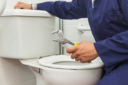 plumber repairing toilet