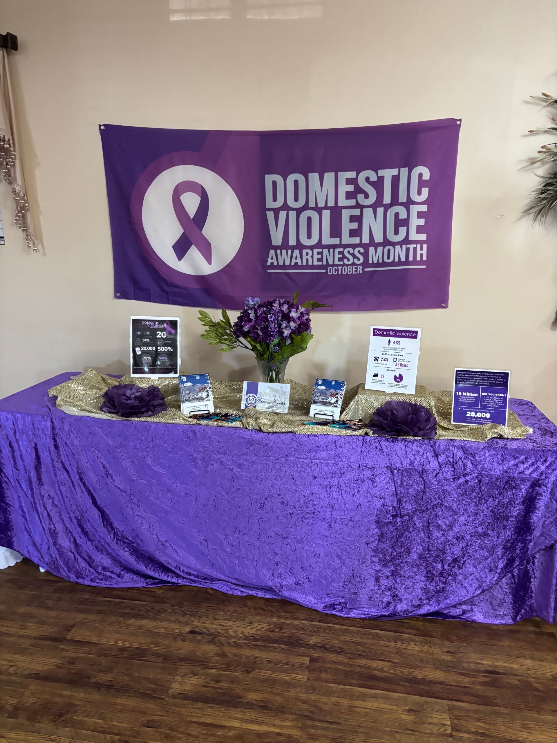 Display for Domestic Violence Awareness Month: purple banner, table with information and decorations.