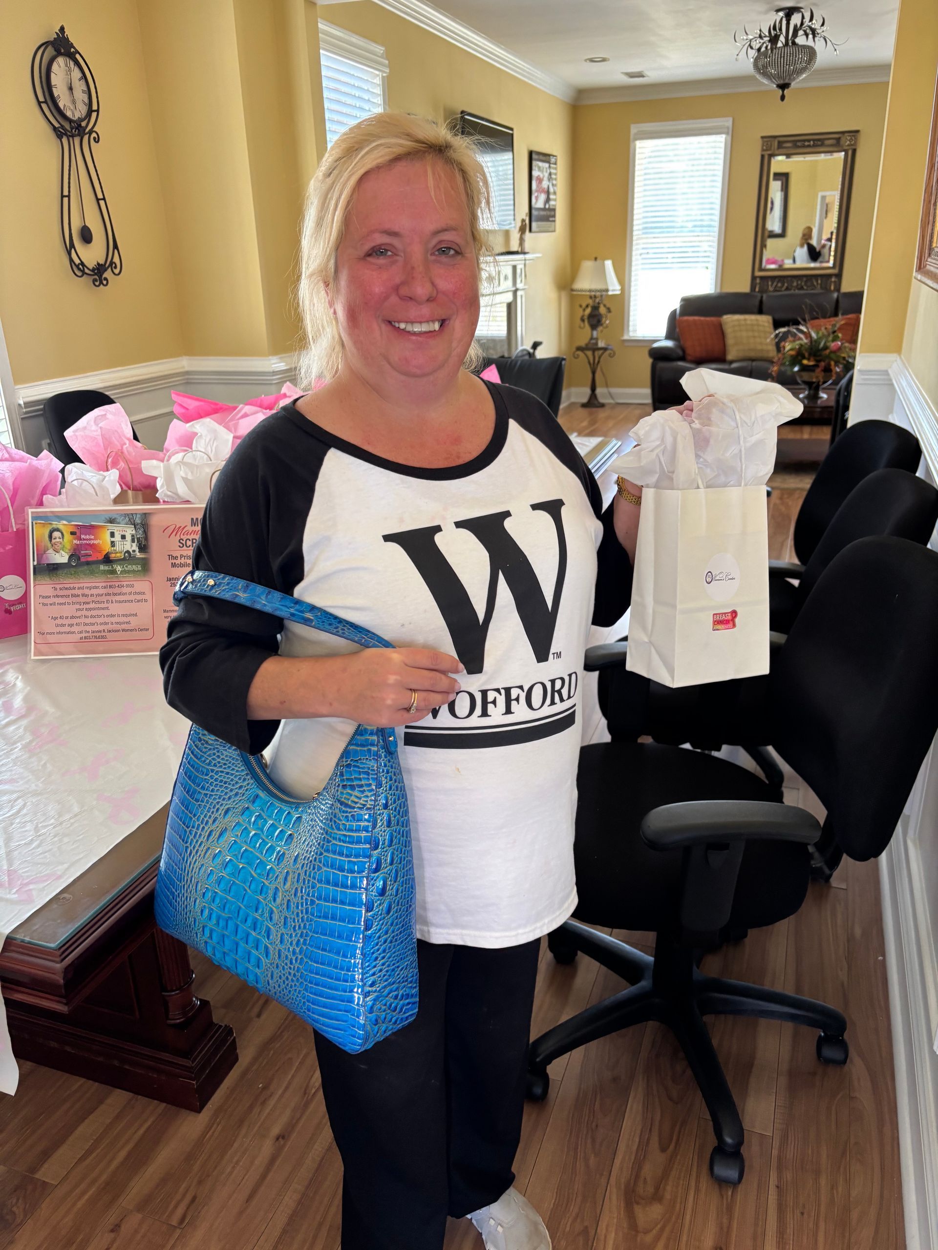 Woman holding gifts, wearing a white shirt with a black 