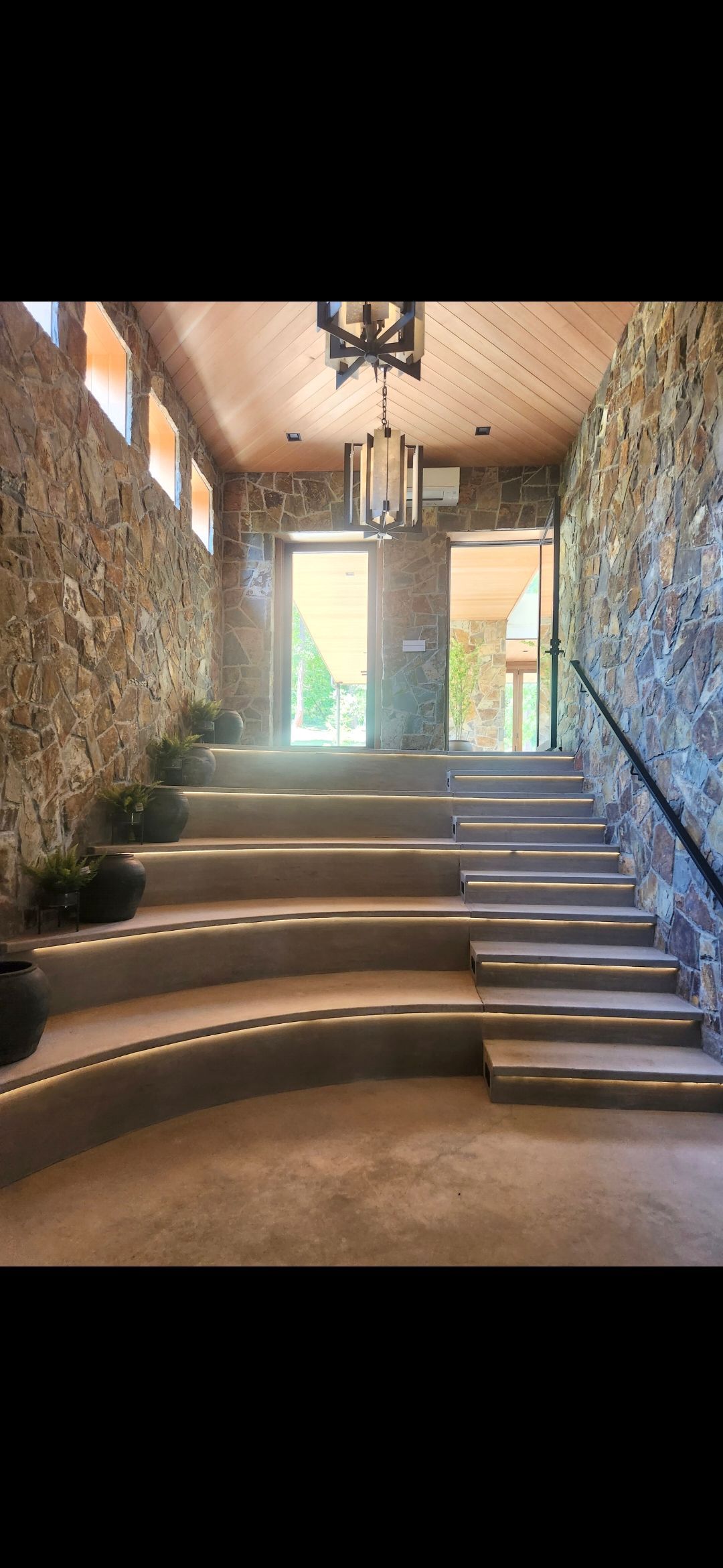 White built-in bookshelves against a white sloped ceiling with skylights, in a room with a light carpet.