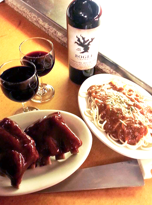 ribs, spaghetti, wine dinner on table