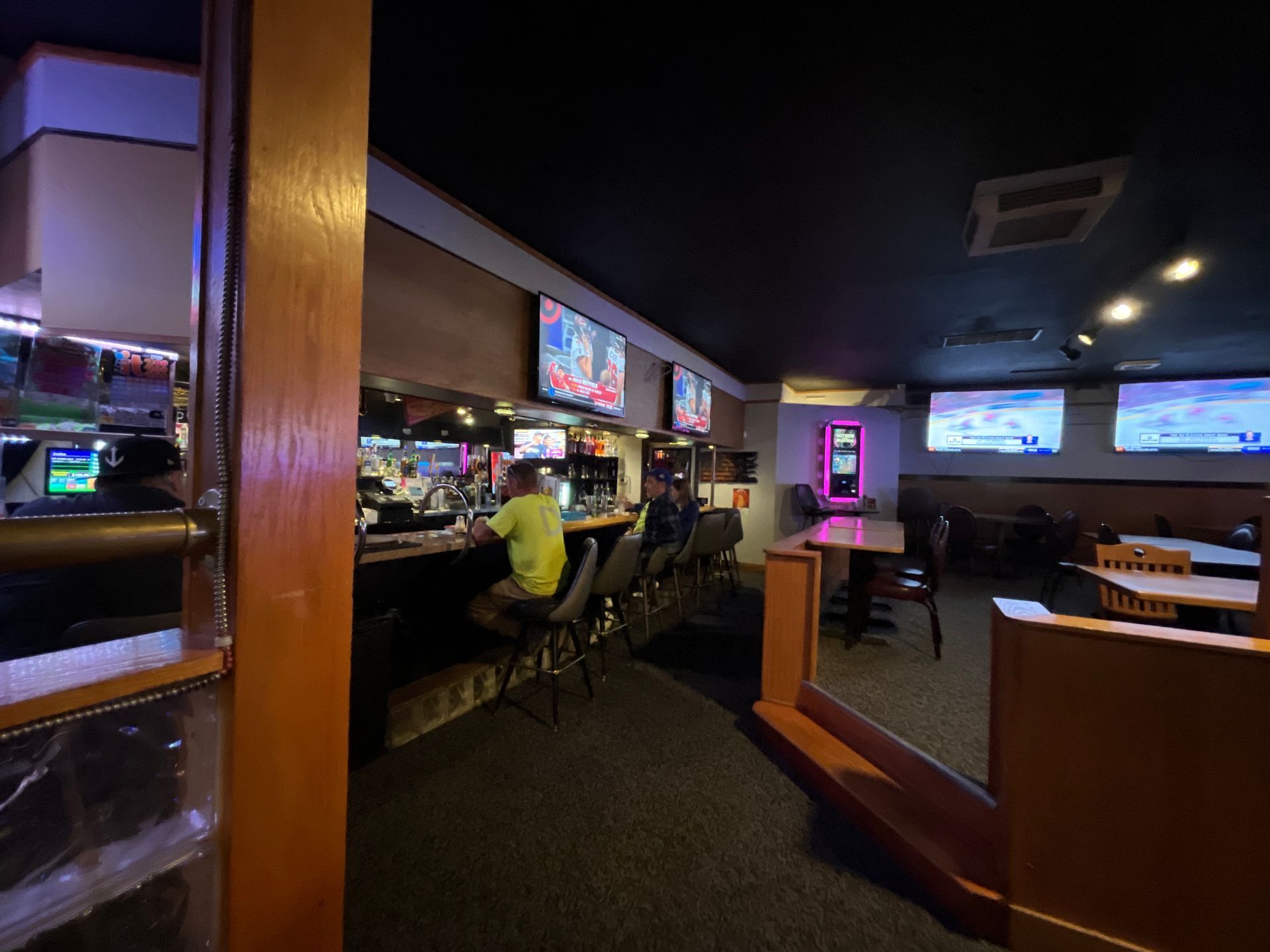 A man is sitting at a bar in a restaurant.