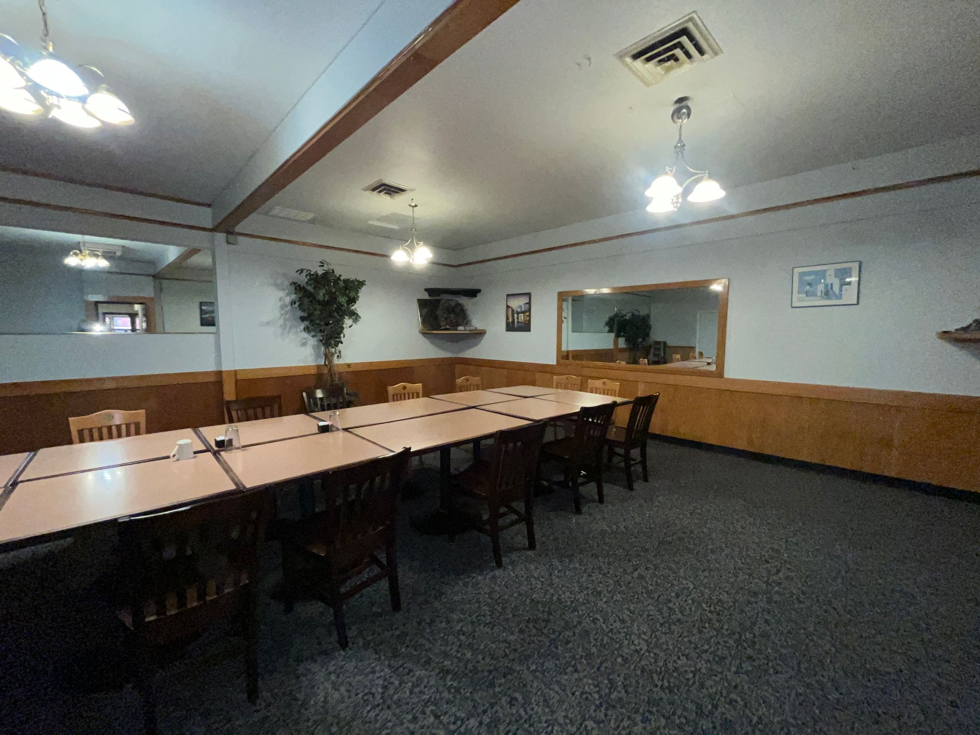 A large meeting room with tables and chairs in it