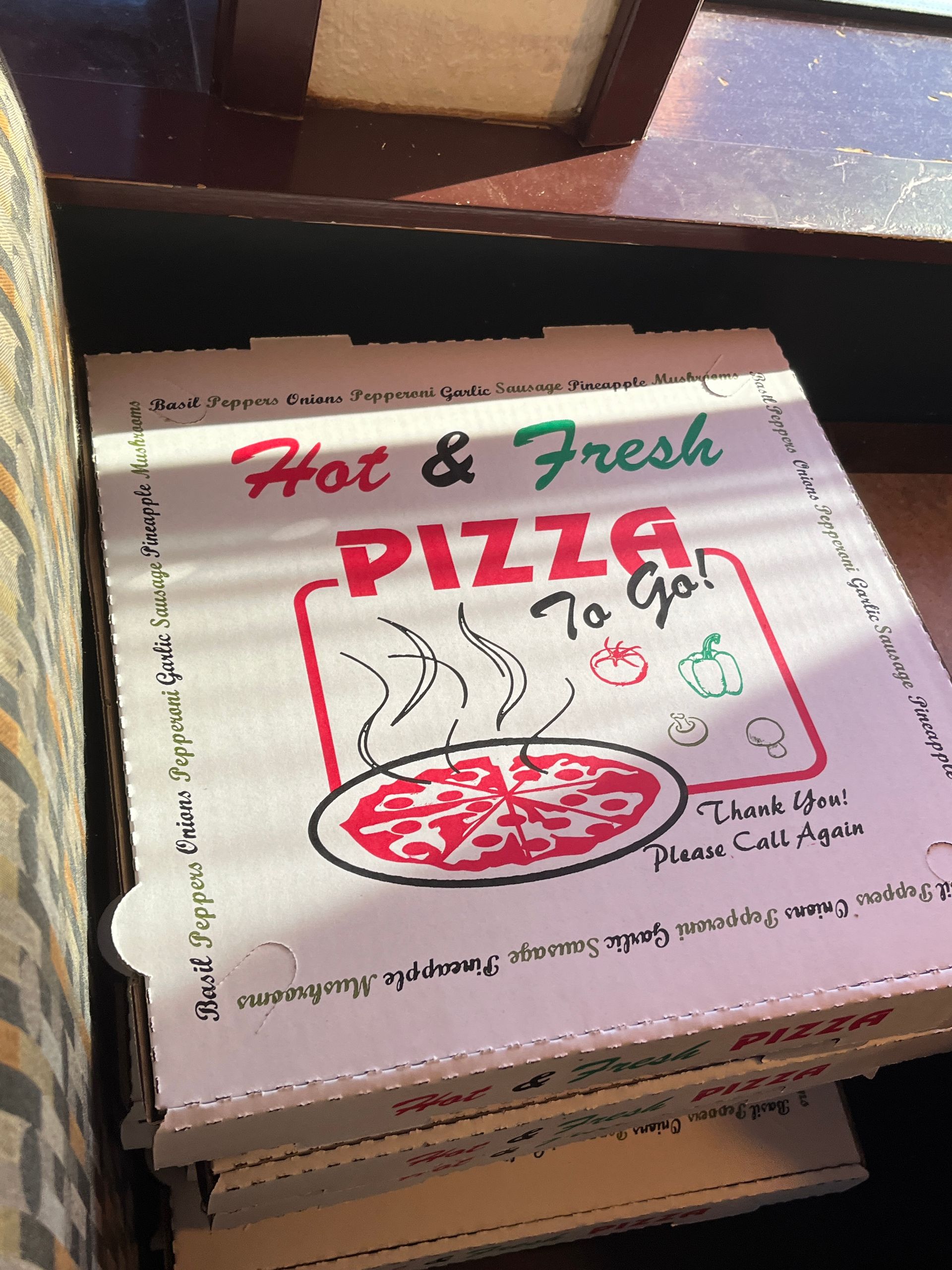 A stack of Cascade pizza boxes that say hot and fresh pizza to go