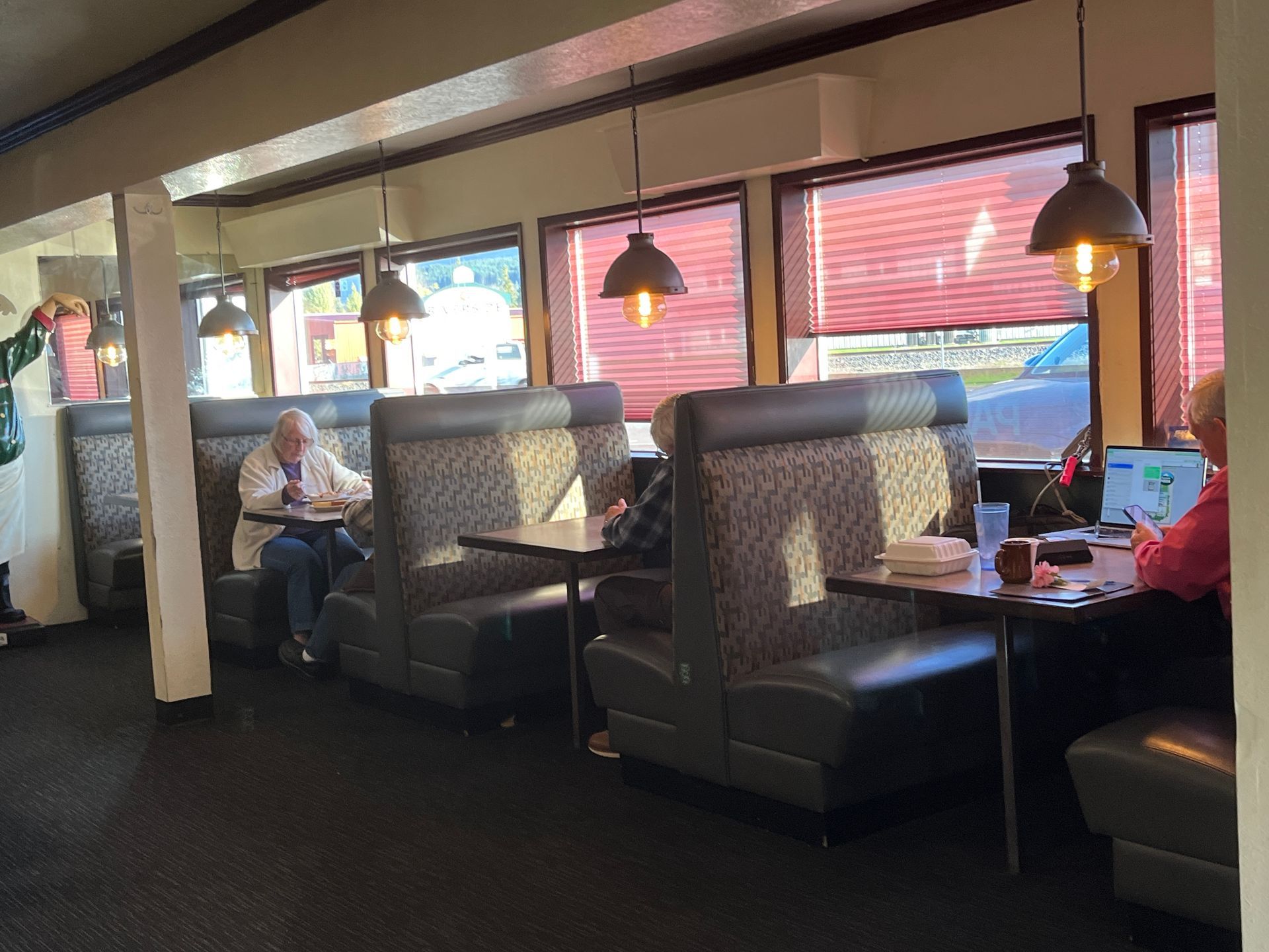 A group of people are sitting at tables in a diner.