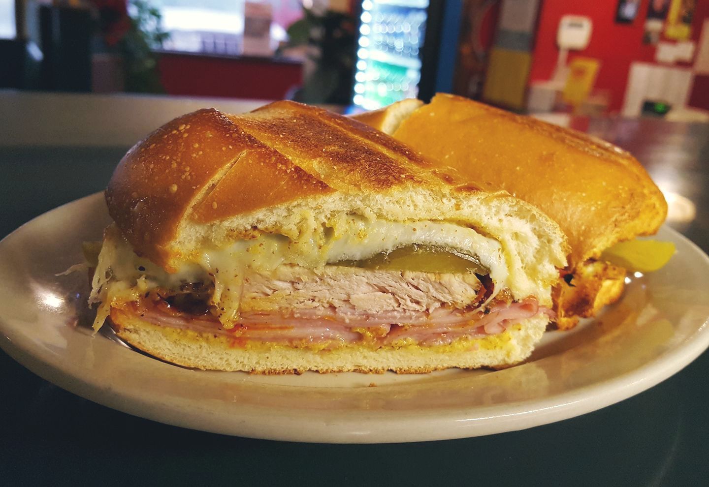 A sandwich is sitting on a white plate on a table.