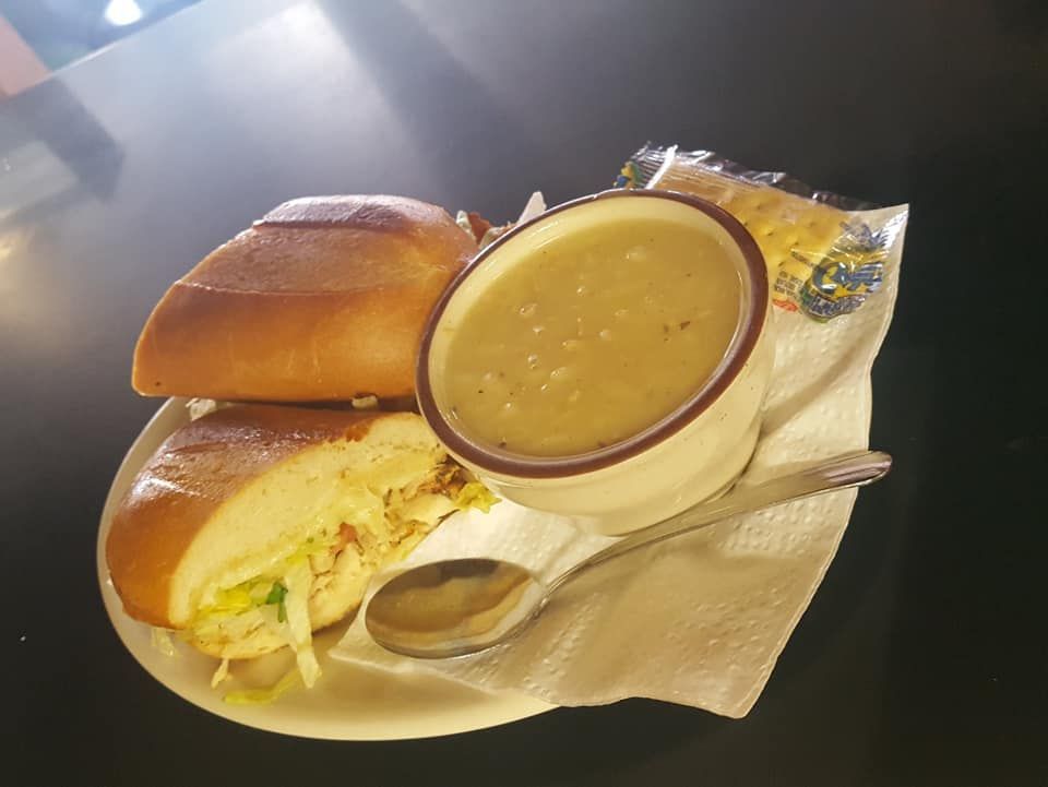 A sandwich and a bowl of Greek lemon chicken soup on a plate