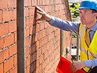 a construction worker is working on a brick wall .
