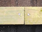a close up of a piece of wood with two screws in it .