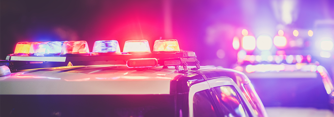 Police car emergency lights flashing in the dark.