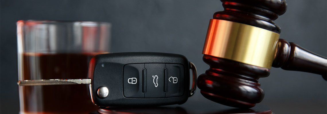 Car keys, a glass of liquor, and a gavel represent DUI and legal consequences.