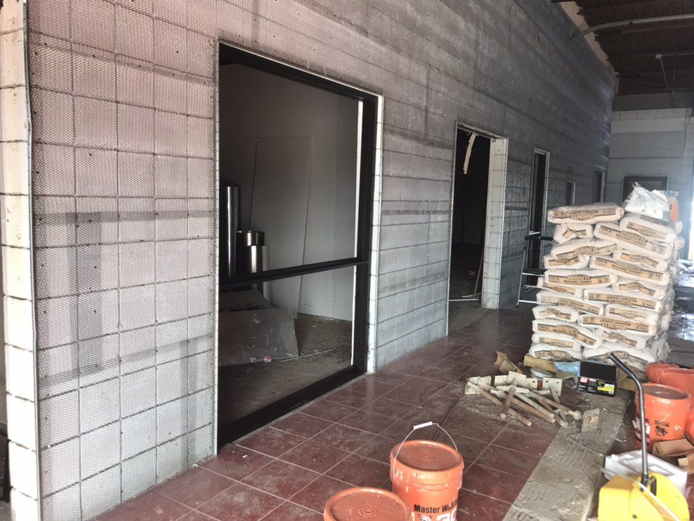 Interior of a building under construction, featuring concrete block walls and open doorways.