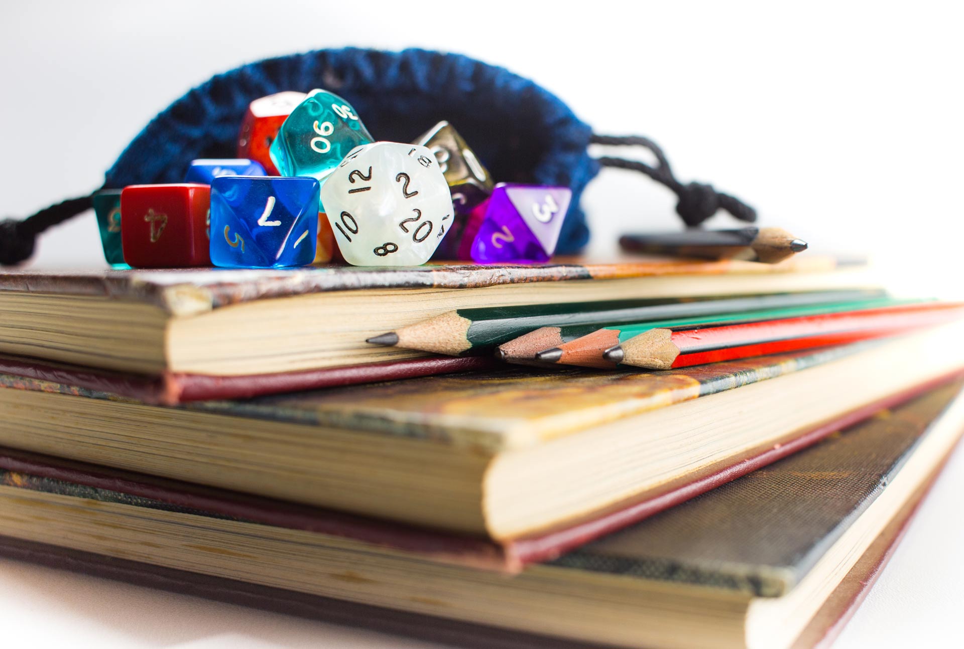 Close-up-of-Dice-and-Pencils-on-top-of-Books