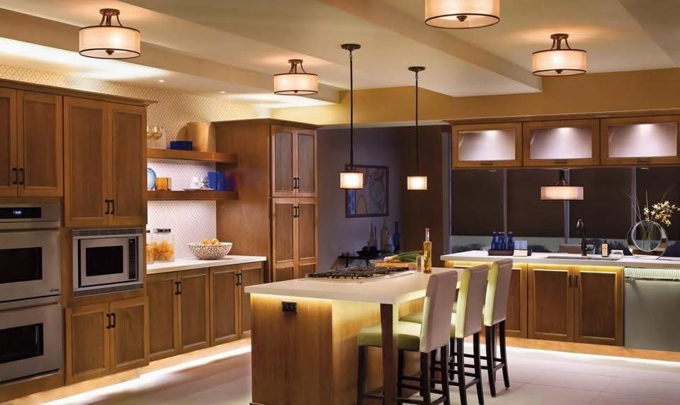 Kitchen with wooden cabinets, island with stools, and overhead lighting.