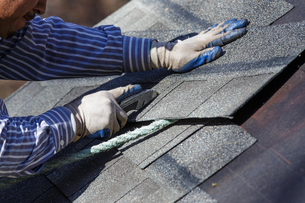 The pe carefully cuts shingles to fit, showcasing precision in roofing craftsmanship.
