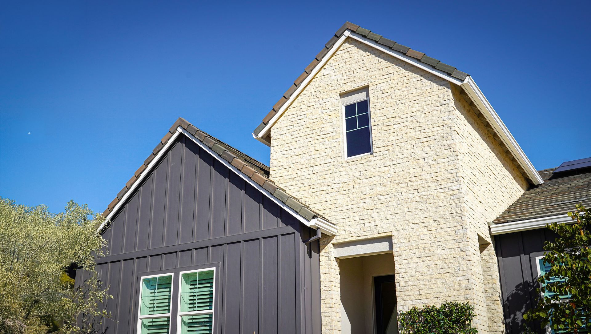 Mixed material board and batten vertical siding with brick stone veneer on custom home | Branson, MO