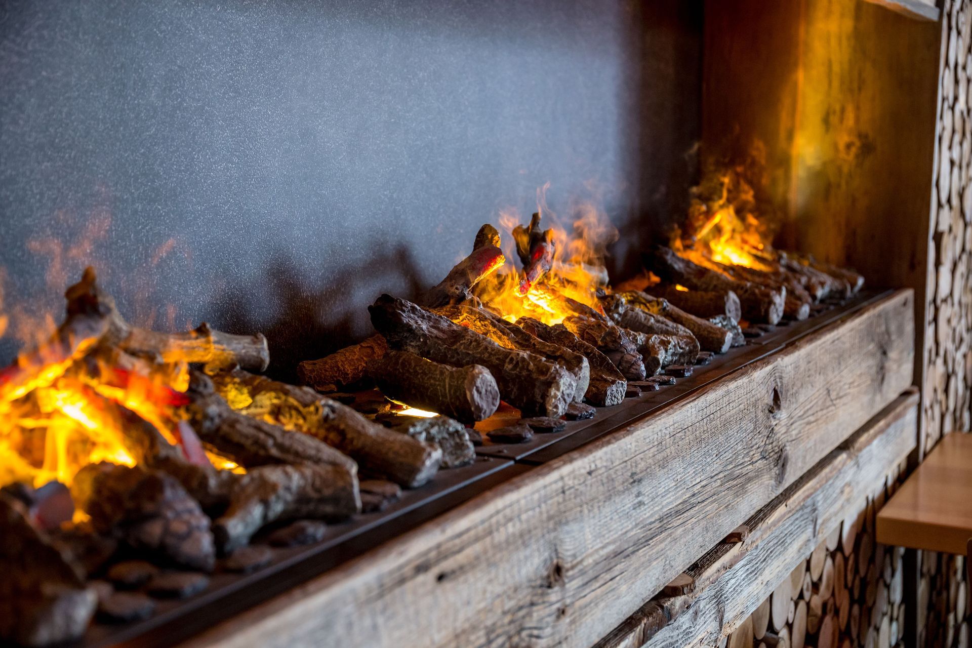 Electric fireplace with faux burning logs and rustic wood mantel | Springfield, MO