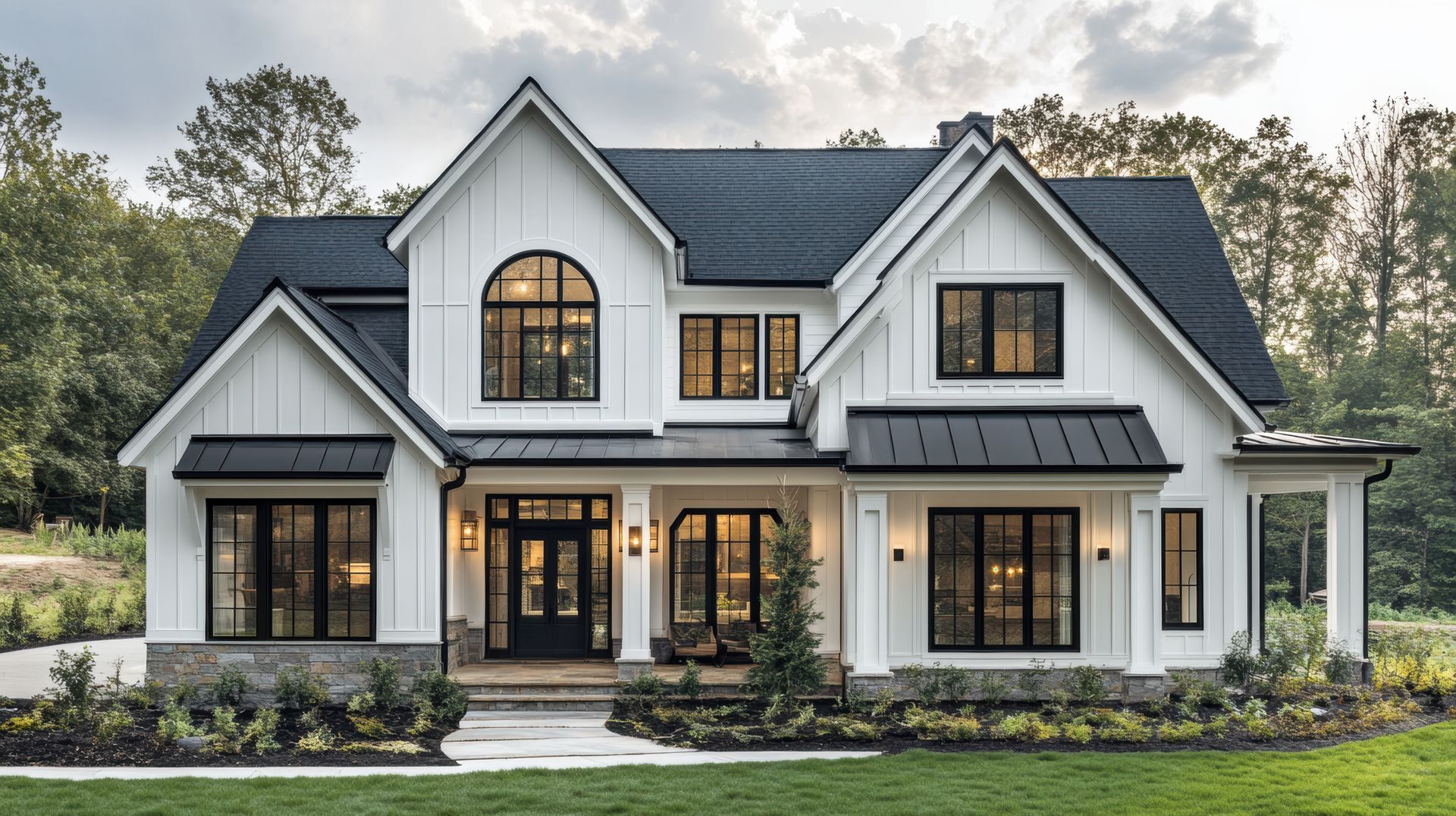 An ICF farmhouse with a black metal roof and vertical siding | Bentonville, AR