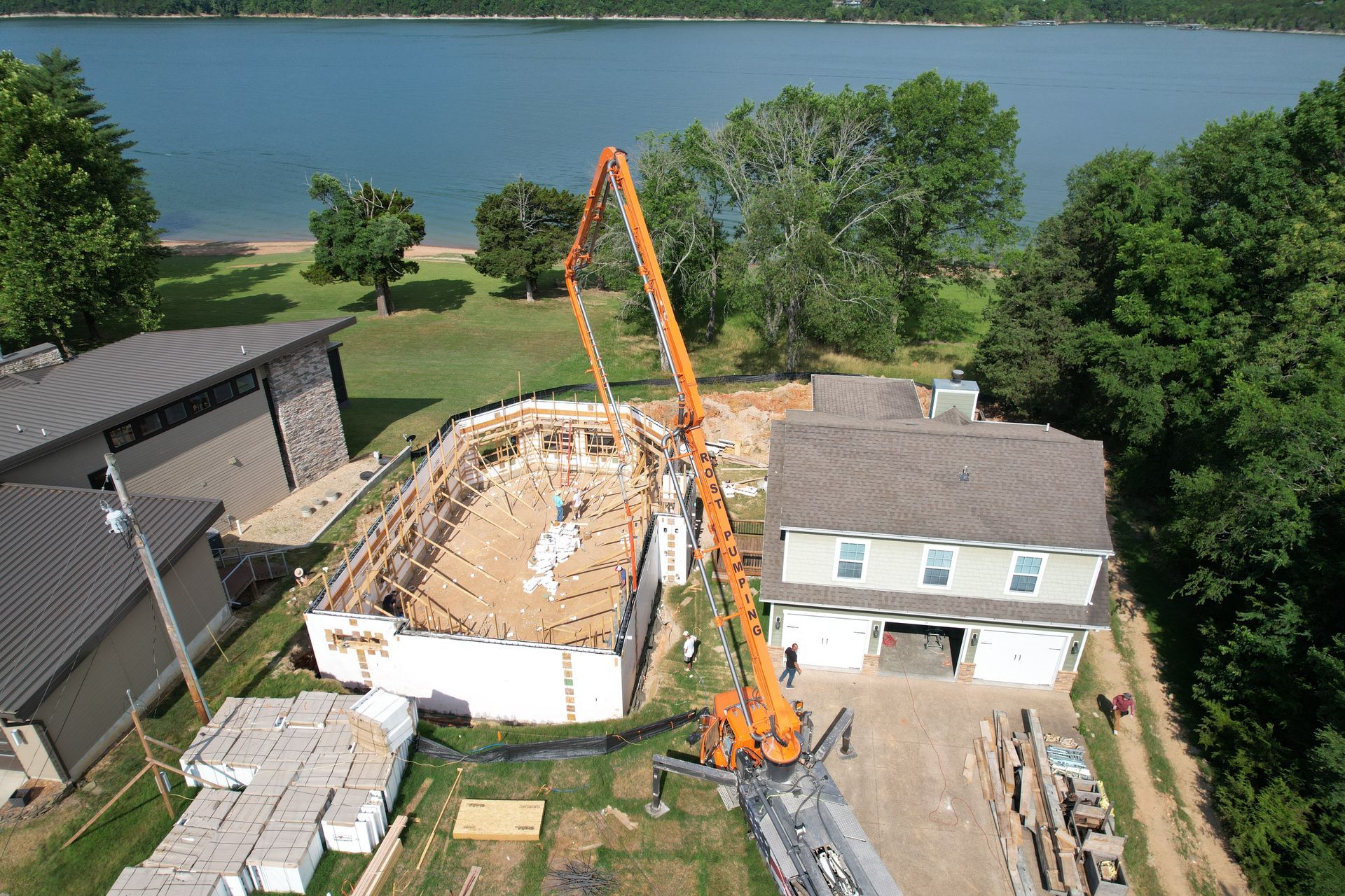 An aerial view of an ICF house being poured next to a lake - Branson ICF Installers