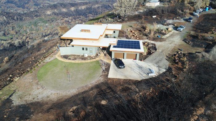 Aerial view of an ICF house virtually unscathed by the wildfire damage you can see around it.