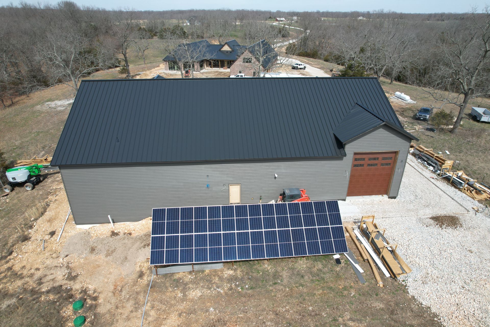 Solar panels installed on the ground behind shop with steel roof | Springfield, MO