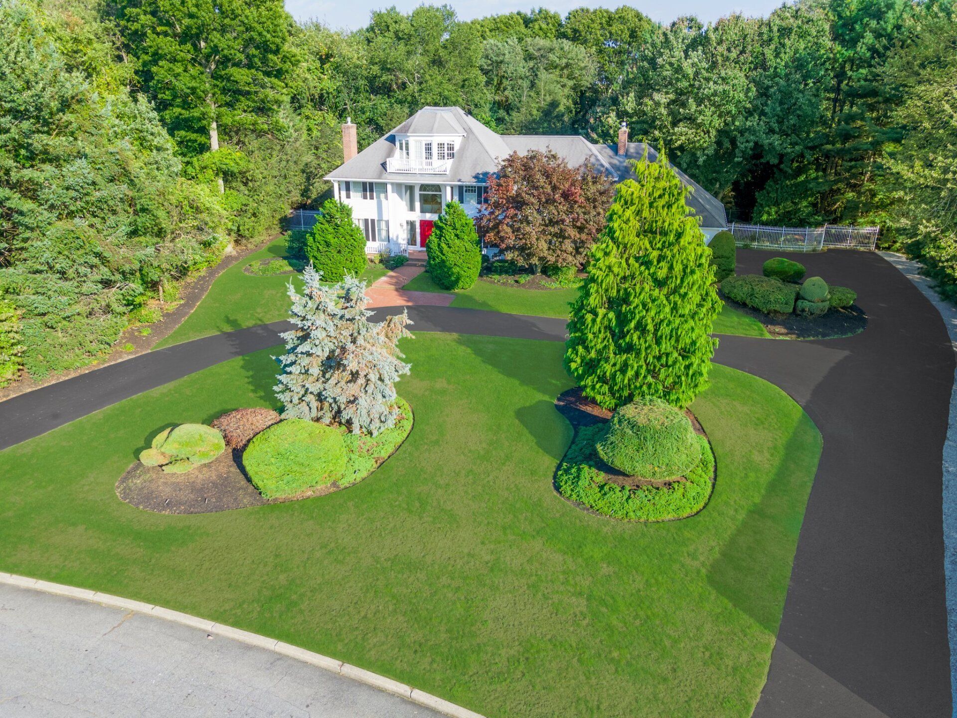 An aerial view of a house with a large driveway