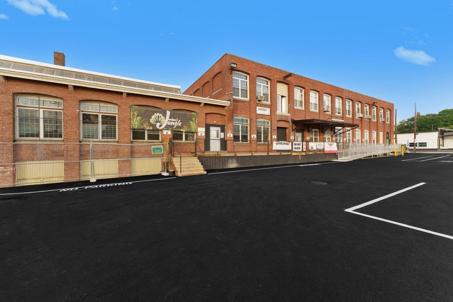 A large brick building with a parking lot in front of it.